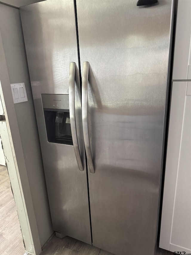 room details featuring light wood finished floors and stainless steel fridge with ice dispenser