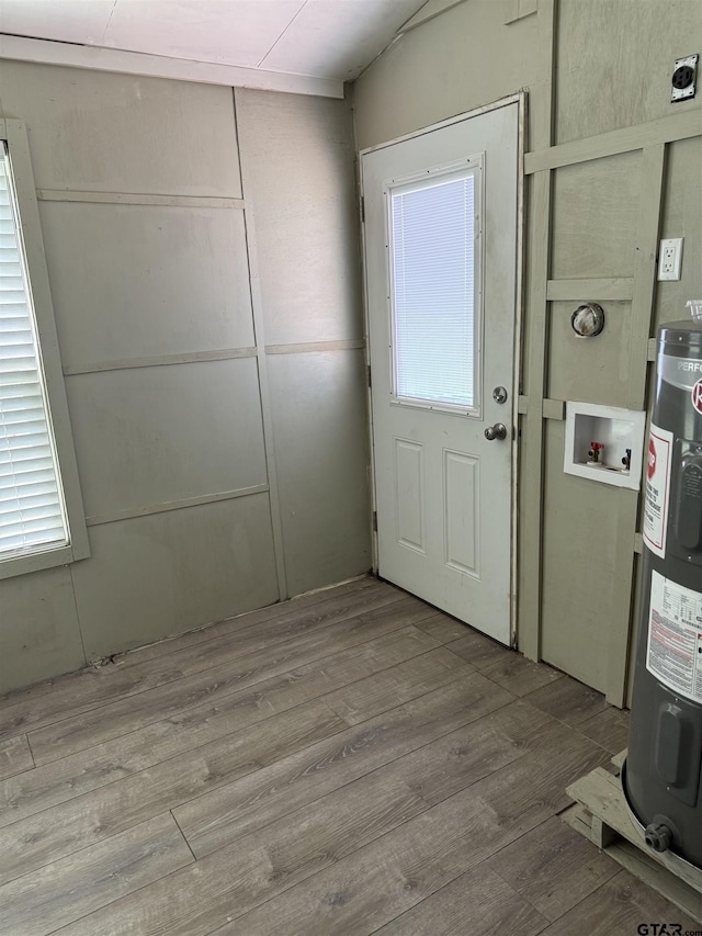 doorway to outside featuring wood finished floors and electric water heater