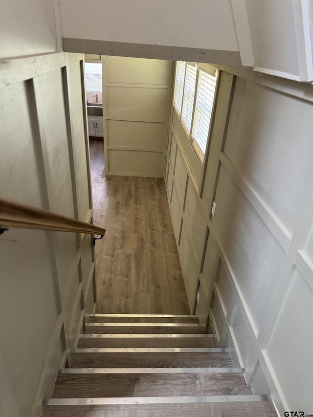 staircase featuring a wealth of natural light and wood finished floors