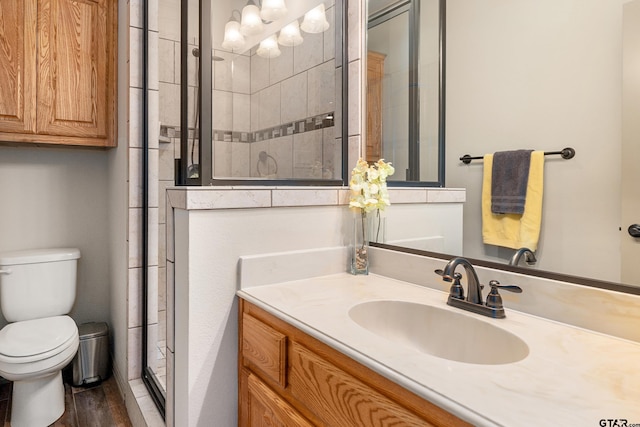 2921 W Alamosa Dr, Terrell, TX 75160 - bathroom featuring a stall shower, toilet, vanity, and wood finished floors