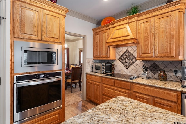 2921 W Alamosa Dr, Terrell, TX 75160 - kitchen with appliances with stainless steel finishes, custom range hood, crown molding, light stone countertops, and wood finished floors