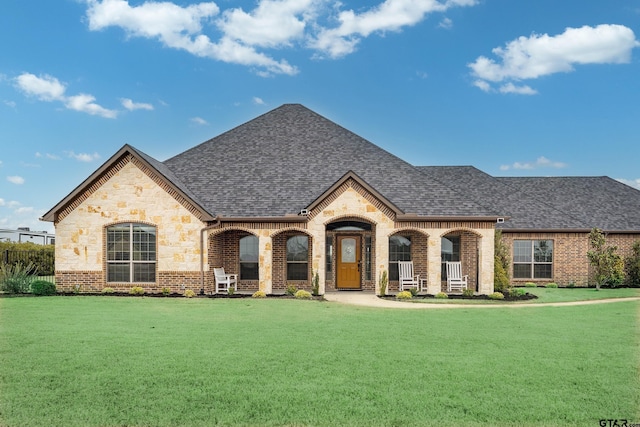2921 W Alamosa Dr, Terrell, TX 75160 - french country style house with brick siding, roof with shingles, a front yard, and stone siding