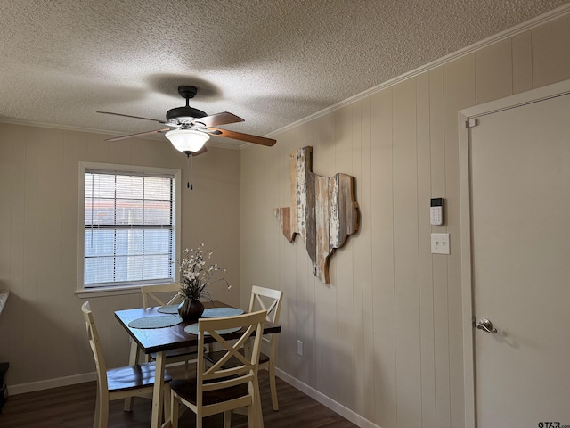 dining space featuring dark wood-type flooring, baseboards, crown molding, a textured ceiling, and a ceiling fan