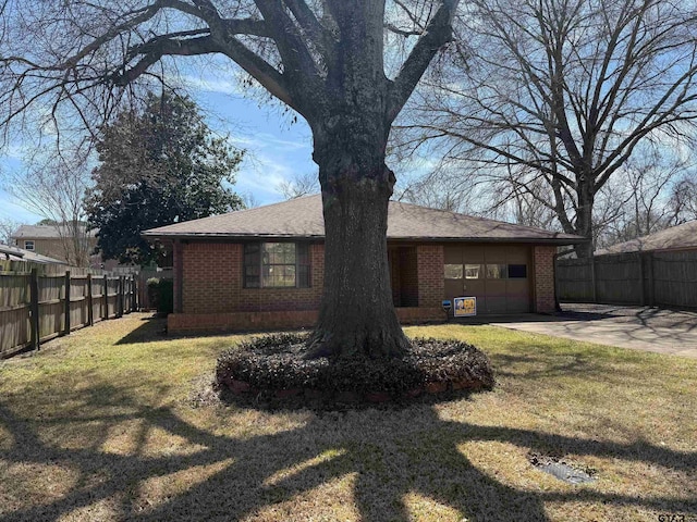 back of property featuring brick siding, a lawn, an attached garage, and fence