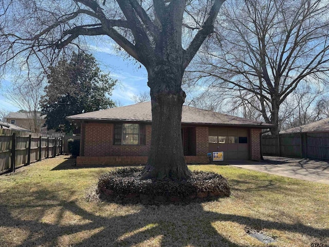 back of property featuring fence, an attached garage, concrete driveway, a lawn, and brick siding