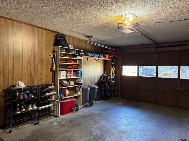 garage with a garage door opener and wood walls