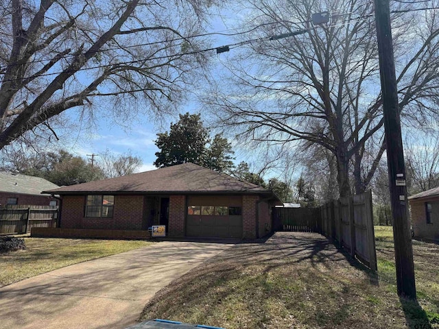 ranch-style home featuring an attached garage, fence, brick siding, and driveway