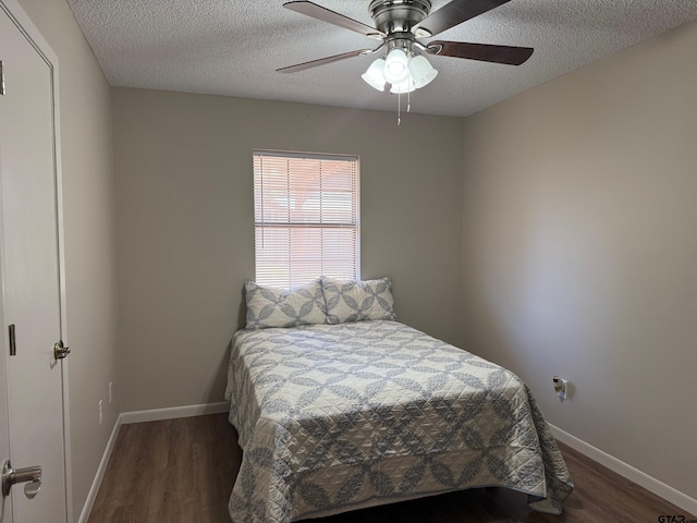 bedroom with baseboards, a textured ceiling, wood finished floors, and a ceiling fan