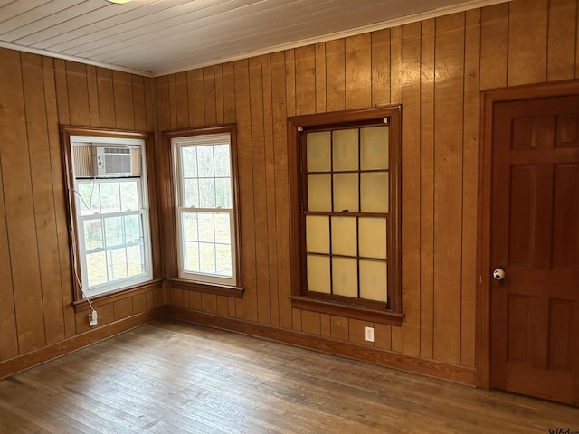 empty room featuring wood-type flooring and wood walls