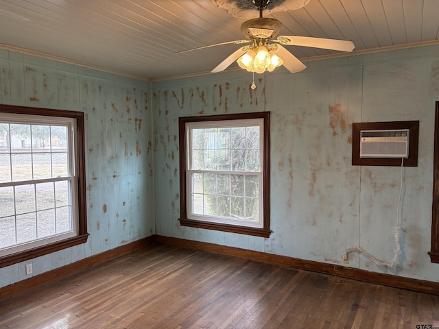 empty room with wood-type flooring, a wall mounted AC, ceiling fan, and crown molding