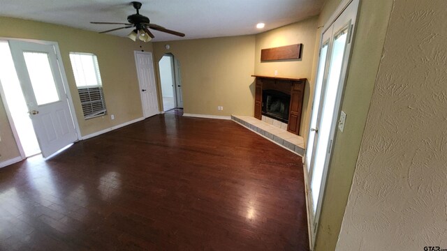 20501 Jak Ln, Chandler, TX 75758 - unfurnished living room featuring dark wood-style floors, a ceiling fan, a fireplace, baseboards, and a textured wall