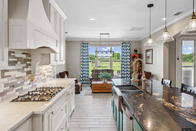 5044 Hidden Ct, Quinlan, TX 75474 - kitchen with visible vents, premium range hood, white cabinets, ornamental molding, and stainless steel appliances