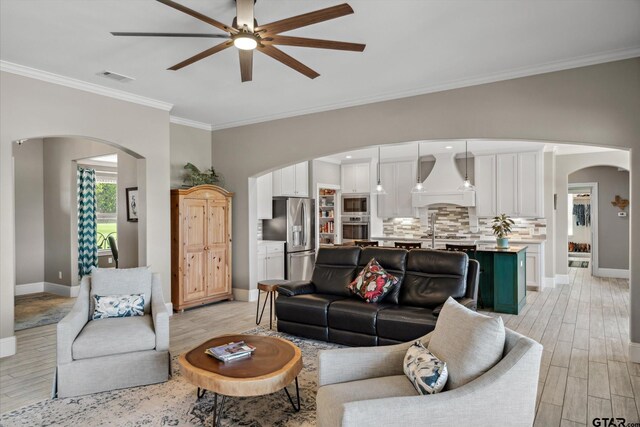 5044 Hidden Ct, Quinlan, TX 75474 - living room featuring ceiling fan, visible vents, arched walkways, baseboards, and light wood-style floors