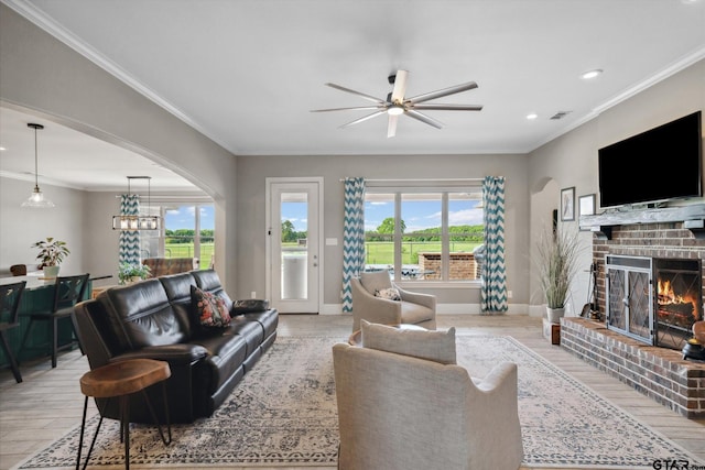 living area with a wealth of natural light, ceiling fan, light wood-type flooring, and visible vents