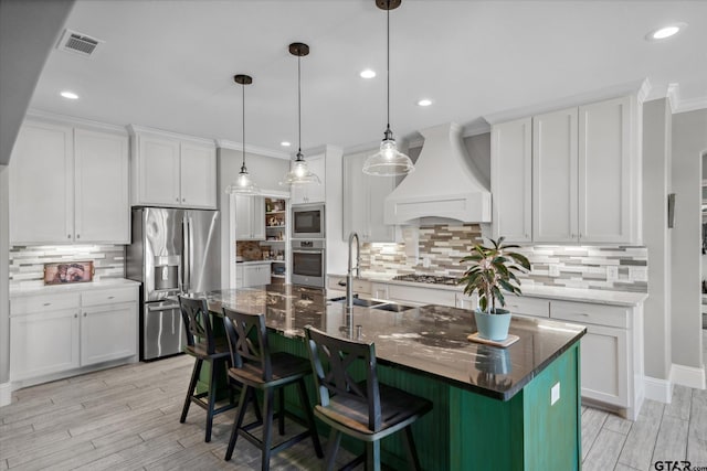 kitchen with stainless steel appliances, visible vents, custom exhaust hood, and tasteful backsplash