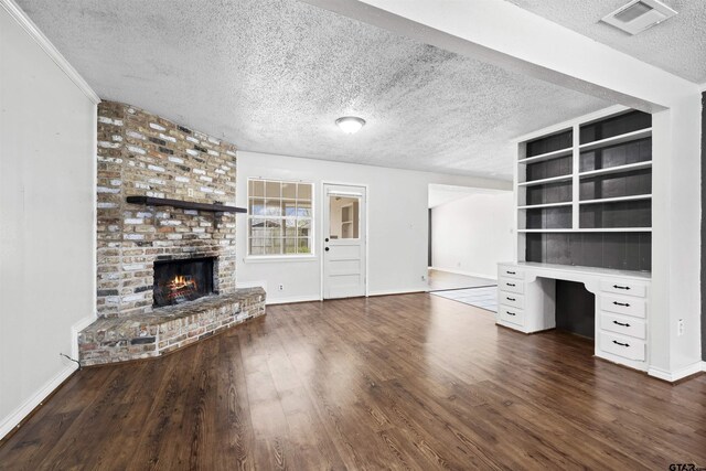 4001 Darrell Ln, Tyler, TX 75701 - unfurnished living room featuring a textured ceiling, a brick fireplace, dark wood finished floors, and baseboards