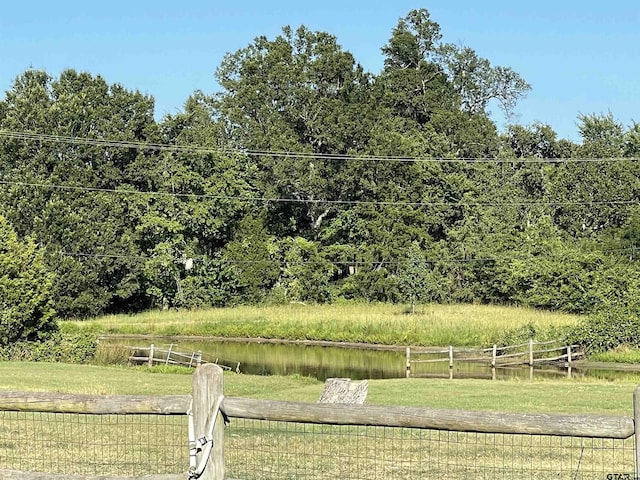 view of yard featuring fence and a water view