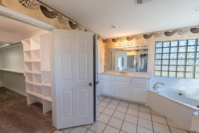 bathroom featuring tile patterned floors, vanity, and a bath