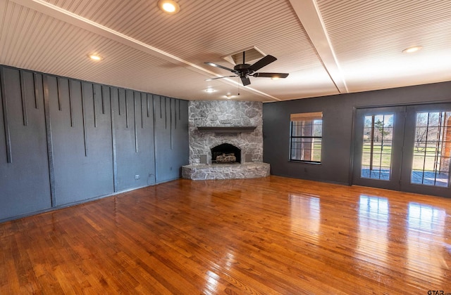 unfurnished living room featuring hardwood / wood-style flooring, ceiling fan, and a fireplace