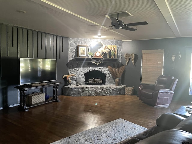 living room featuring a stone fireplace and wood finished floors