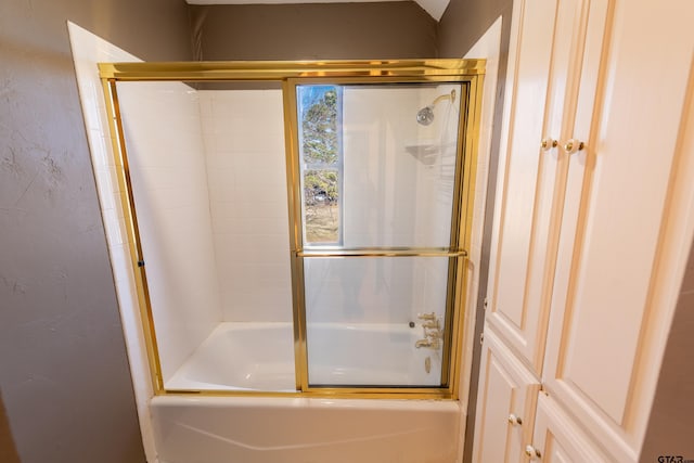 bathroom with bath / shower combo with glass door