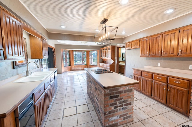 kitchen with pendant lighting, black appliances, sink, a notable chandelier, and a kitchen island