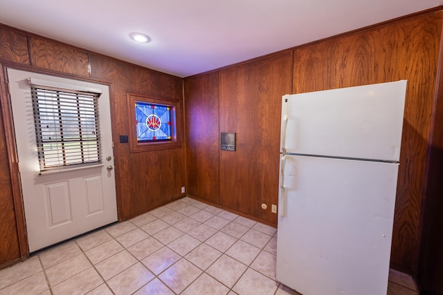 interior space with wooden walls and light tile patterned floors