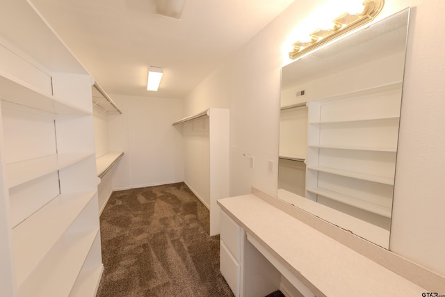 spacious closet featuring dark colored carpet