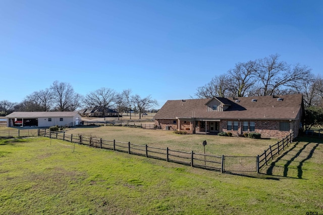 view of yard featuring a rural view, a carport, driveway, and fence