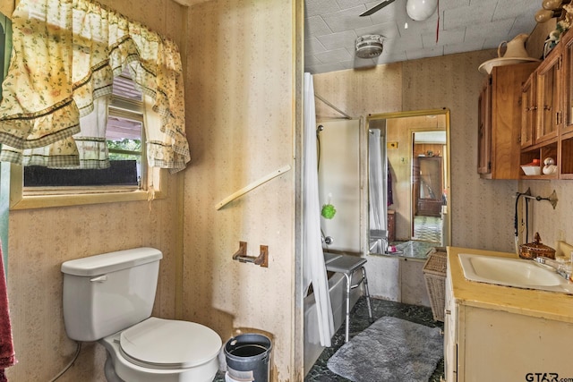 500 W Mclean St, Talco, TX 75487 - full bath with vanity, toilet, a shower, wallpapered walls, and ceiling fan
