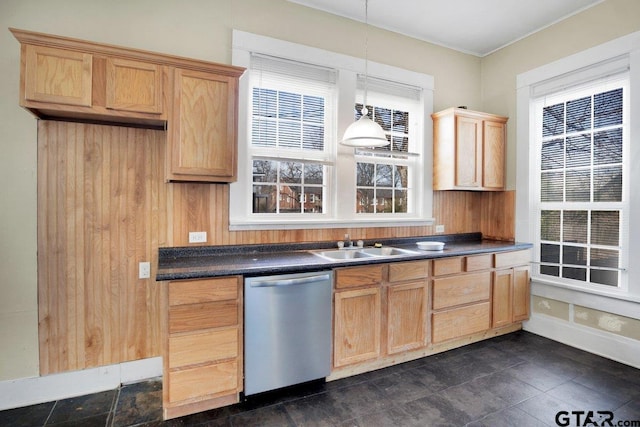 kitchen with pendant lighting, dark countertops, a sink, dishwasher, and baseboards