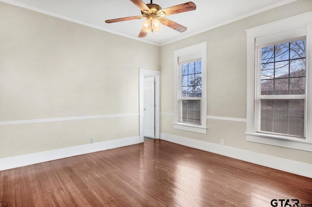 spare room with a ceiling fan, crown molding, baseboards, and wood finished floors