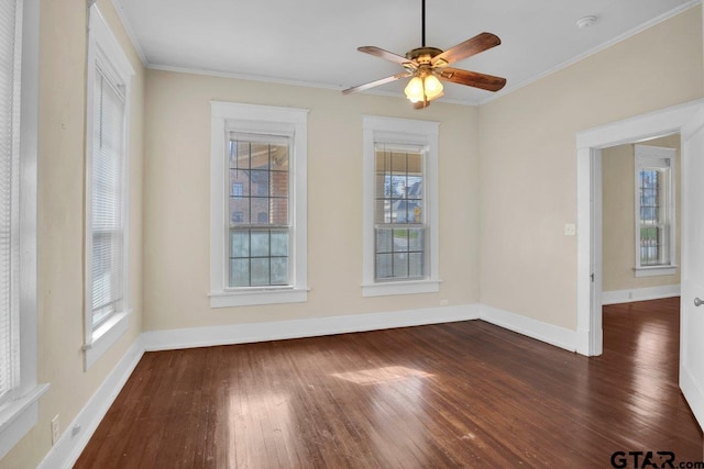 spare room with ornamental molding, dark wood finished floors, and baseboards