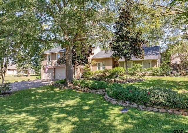 view of front of property with brick siding, driveway, an attached garage, and a front lawn