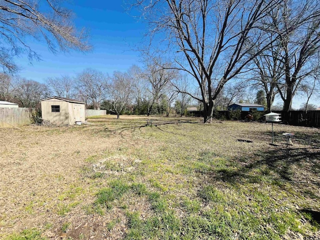 view of yard with an outbuilding, a storage shed, and fence