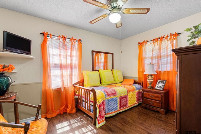 bedroom featuring ceiling fan, a textured ceiling, and dark hardwood / wood-style floors