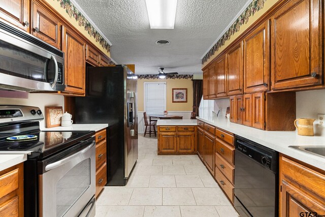 kitchen with appliances with stainless steel finishes, a textured ceiling, and ceiling fan