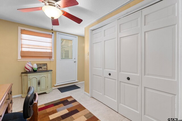 tiled home office with a textured ceiling and ceiling fan