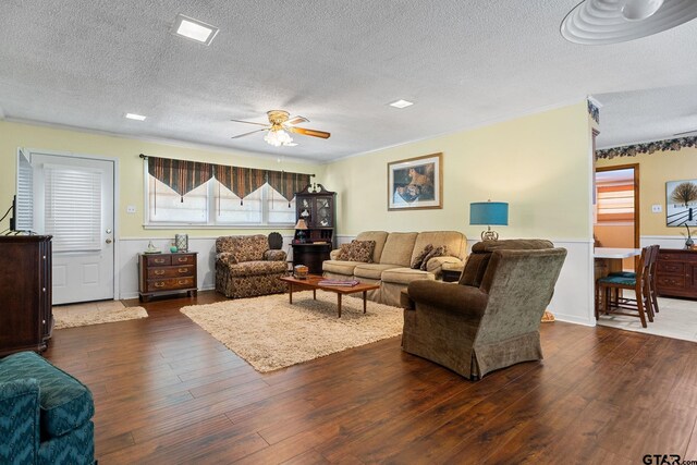 living room with a textured ceiling, dark hardwood / wood-style floors, and ceiling fan