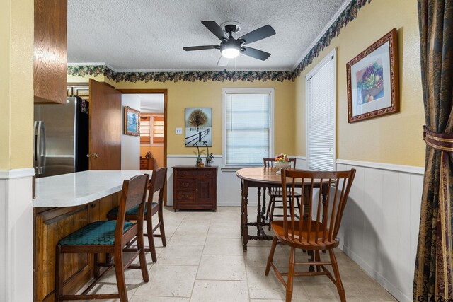 dining area featuring crown molding, a textured ceiling, and ceiling fan