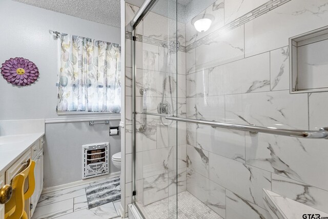 bathroom featuring toilet, a shower with door, a textured ceiling, heating unit, and vanity