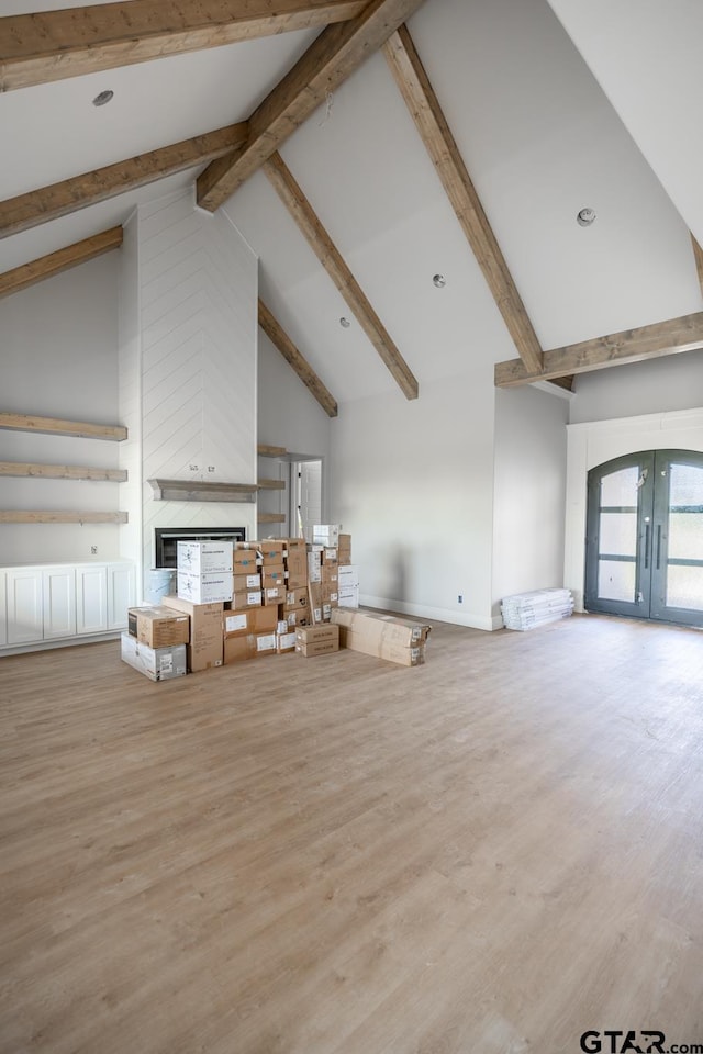 529 Eland Way, Bullard, TX 75757 - unfurnished living room featuring high vaulted ceiling, french doors, beamed ceiling, a multi sided fireplace, and wood finished floors