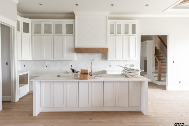 529 Eland Way, Bullard, TX 75757 - kitchen featuring a center island with sink, white cabinetry, decorative backsplash, crown molding, and light wood-style floors
