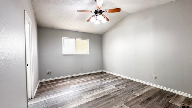 empty room with light wood-type flooring, a textured ceiling, vaulted ceiling, and ceiling fan