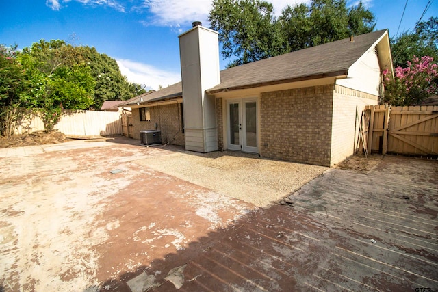 rear view of property featuring french doors and cooling unit