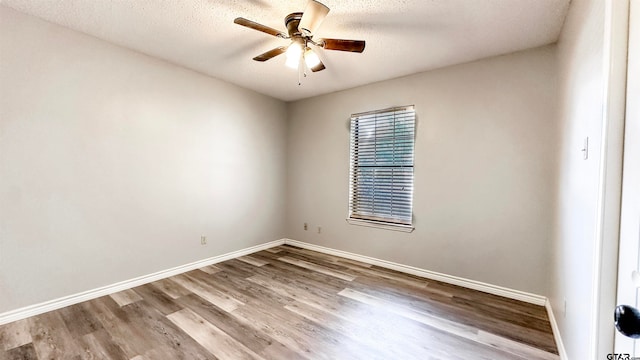 empty room with ceiling fan, light hardwood / wood-style floors, and a textured ceiling