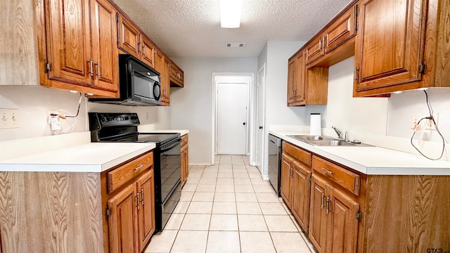 kitchen featuring sink, light tile patterned floors, a textured ceiling, and black appliances