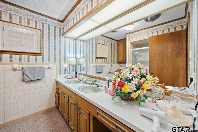 bathroom featuring vanity, a shower with door, and a textured ceiling