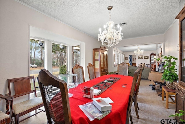 dining area featuring light carpet, a notable chandelier, ornamental molding, and a textured ceiling