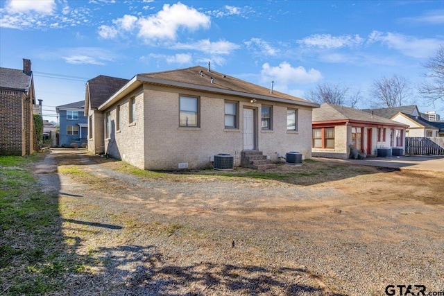 back of property with central AC and brick siding